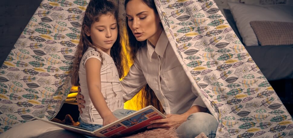 mae e filha lendo juntas no quarto